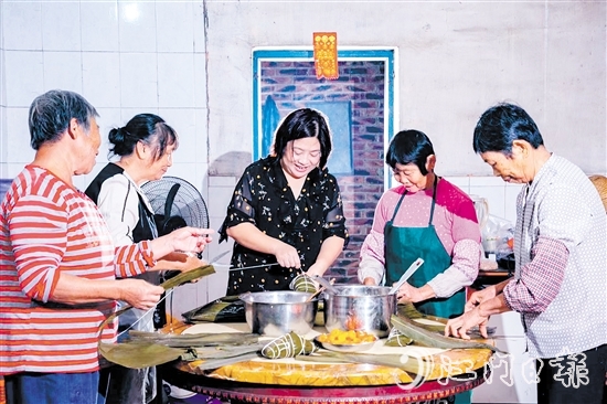 非遺傳承人呂艷卿正在傳授柴火粽的制作技藝。