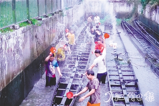 在水口鎮(zhèn)龍東村委會(huì)欖沖村，村民們合力將深埋河底的龍舟“喚醒”，為即將到來的端午龍舟賽事做準(zhǔn)備。
