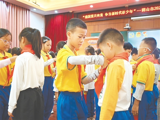 活動(dòng)中，老隊(duì)員熟練地為新隊(duì)員系上紅領(lǐng)巾。